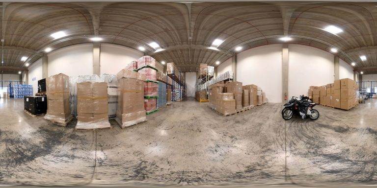 Une vue à 360 degrés d'un entrepôt avec des motos et des boîtes pour TCL Transport.